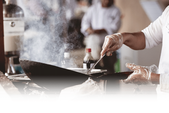 A closeup shot of a chef cooking with a blurred background