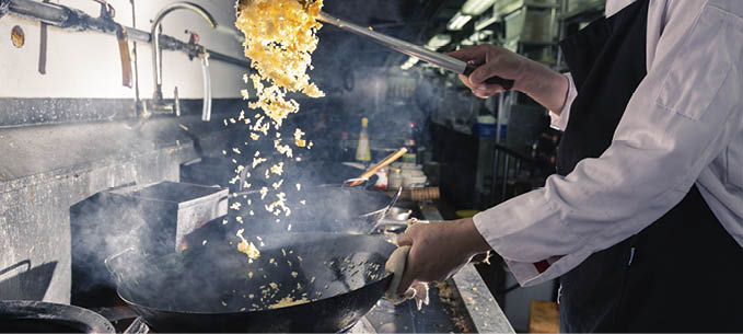 Chef is stirring vegetable in wok