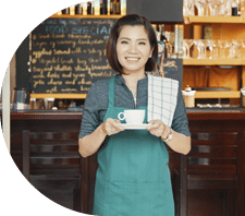 Pretty Vietnamese waitress offering a cup of coffee